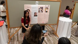 Attendee taking photo of poster presenter